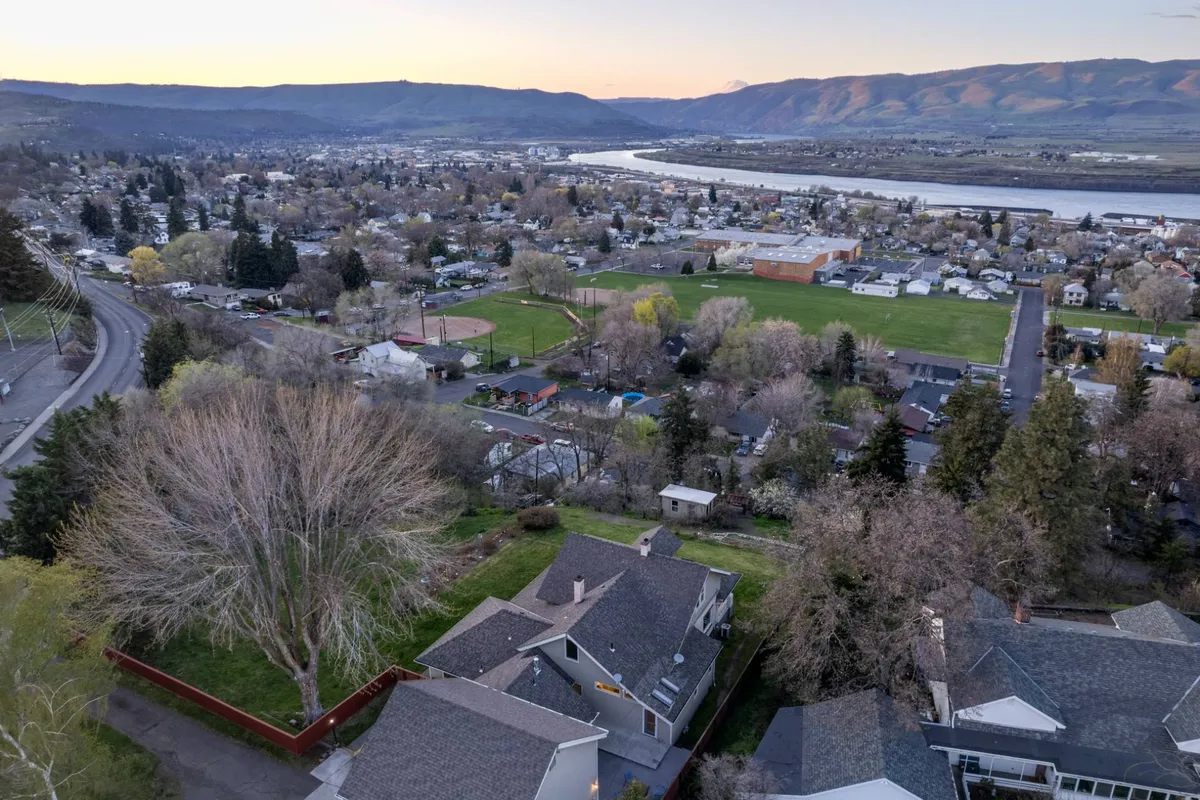 This exterior view looks out over the Columbia River, green fields, residential areas, and the distant mountains. The tranquil scene showcases the natural beauty and recreational potential of the surrounding landscape, aligning with the adventure-focused content of the section.
